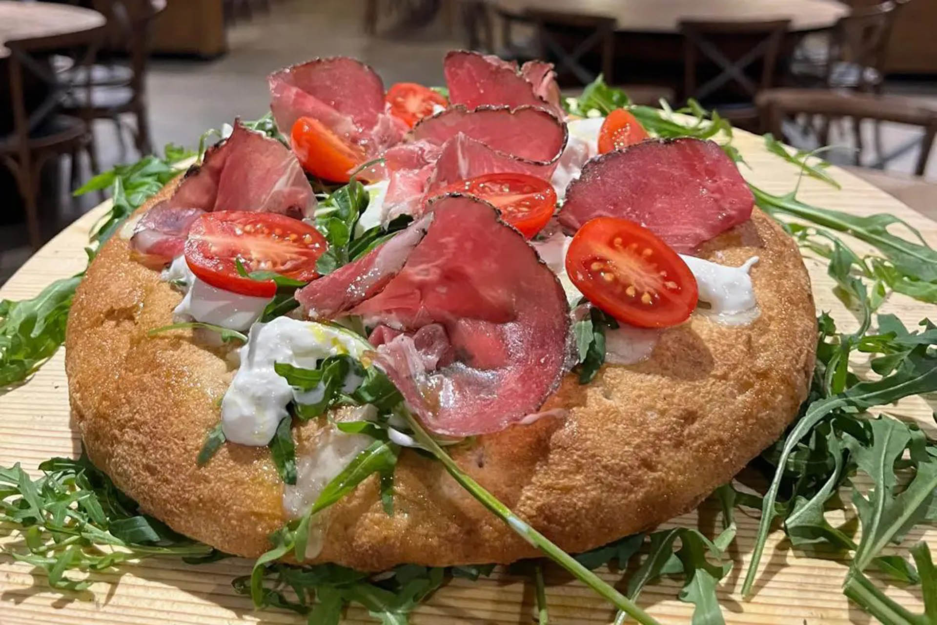 Pizza gourmet con stracciatella coppa stagionata e pomodorini